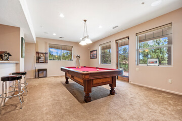 In the center of the room, there is a billiard pool table present