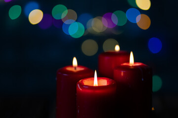 candles burning against holiday lights background