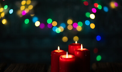 candles burning against holiday lights background