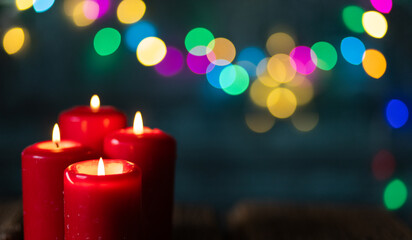 candles burning against holiday lights background