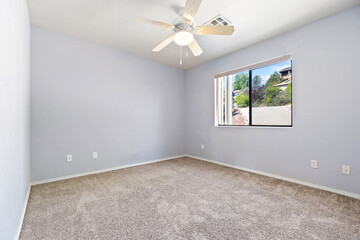 Spacious Light Room with Ceiling Fan and Window View