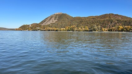 Idillic landscape of wide river Danube at sunset, autumn, mountain and Visegrad castle on opposite bank, Hungary.