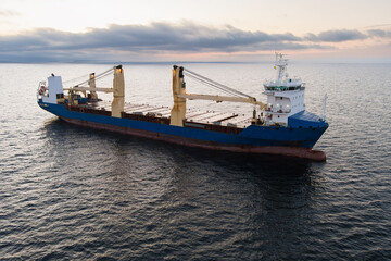 Naklejka premium Aerial view of a large blue general cargo ship sailing on the Baltic Sea near Estonia during a calm sunset