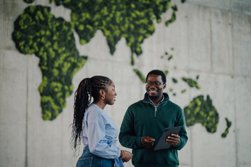 Colleagues discussing project with green world map