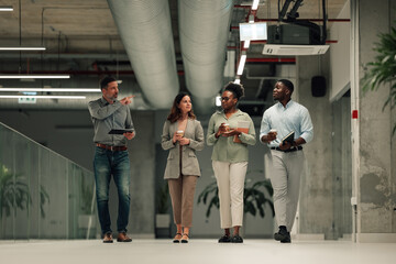 Diverse business people walking discussing ideas in office