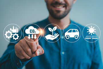 Man interacts with a digital interface displaying icons representing carbon reduction renewable energy and sustainable practices for environmental conservation and a greener future initiative
