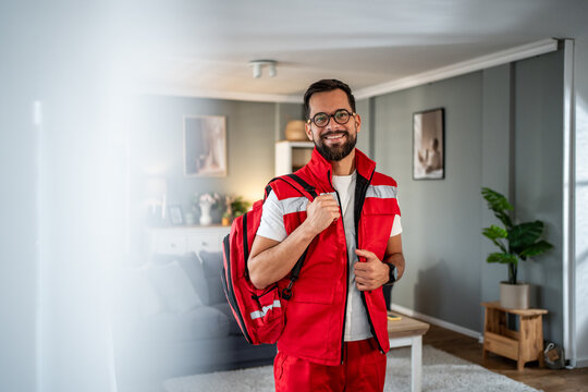 Male paramedic smiling at camera wearing medical uniform - Powered by Adobe