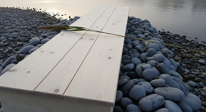 Simple wooden bench on a bed of smooth river stones.
A long, light-colored wooden plank surface, possibly a bench or a lid, rests atop a large mound of smooth, grey river stones or pebbles - Powered by Adobe
