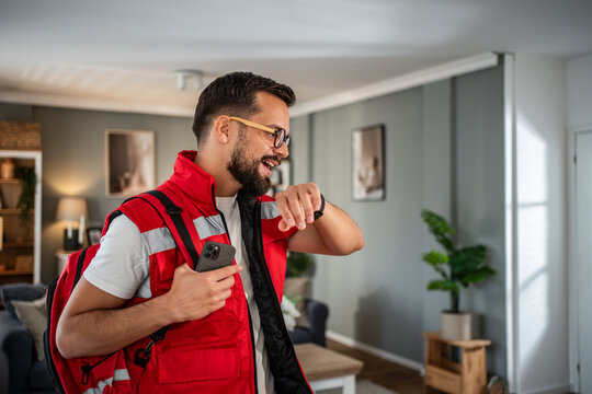 Male paramedic checking time for home visit