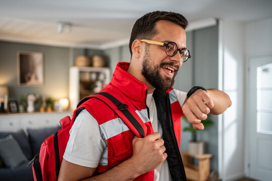 Paramedic smiling checking watch during home visit