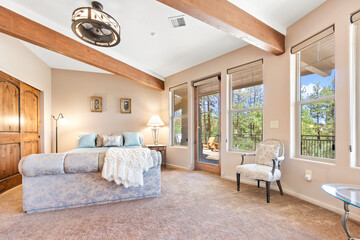 A large bedroom with a king bed, dresser, nightstand, and TV