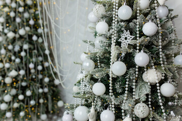 The artificial Christmas tree, made of environmentally friendly materials, is decorated with white...