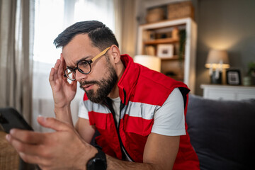 Man experiencing stress and headache while receiving bad news on phone