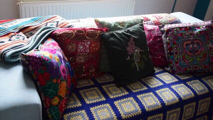 Close shot of a sofa with colorful cushions and sunlight shining on it