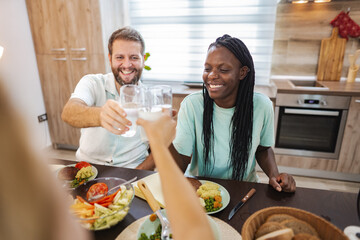 Friends enjoy a joyful dinner together in a cozy kitchen