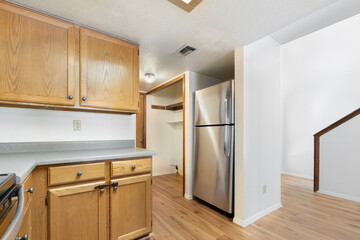 A bright kitchen with elegant wooden cabinets and a shiny fridge