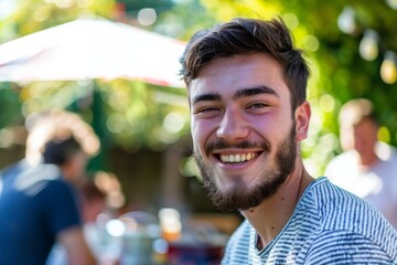 Young man smiling happily in a sunny outdoor setting