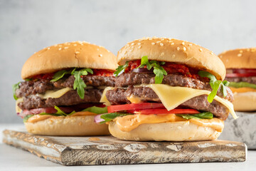 Delicious double burgers with fresh toppings and sauces served on a wooden platter during a casual dining experience