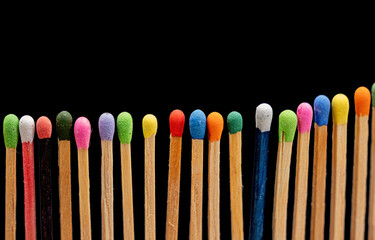 a close-up of wooden matchsticks with vibrant on black background