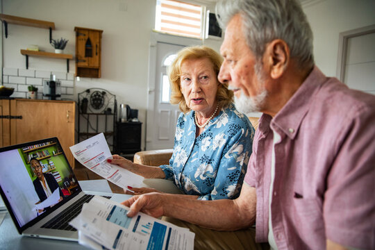 Senior couple concerned during video call about bills at home