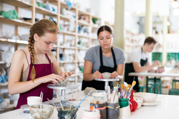Pottery lesson - teenagers intently create dishes from clay