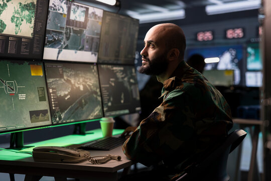 Military early warning systems operator in command center monitoring incoming enemy aerial attacks. Middle Eastern army agent maintains air space superiority with radar during armed conflict