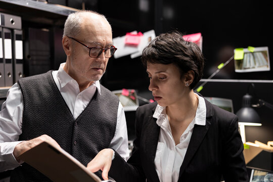 Law enforcement agents connecting clues on a mystery board, analyzing case files and confidential information during a clandestine operation to expose organized crime. Incident room.