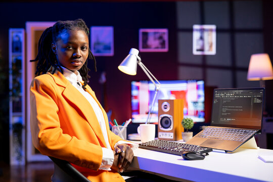 Portrait of programmer at desk typing code on laptop, developing software programs, entering commands. African american woman at home fixing errors in application, implementing new features - Powered by Adobe