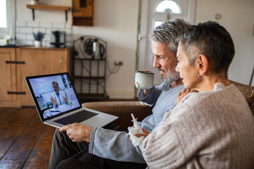 Mature couple consults telehealth doctor at home, concerned