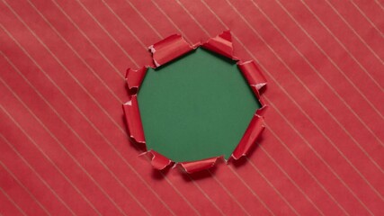 Christmas wrapping paper tears from the center on a green background. Stop motion. Layout for discounts, text, etc