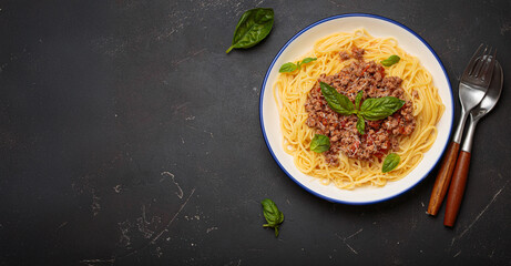 Delicious spaghetti bolognese garnished with fresh basil and grated parmesan, served on a white...