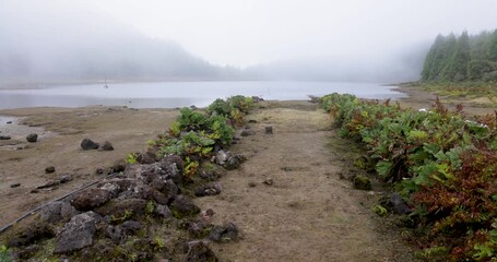 A foggy day with a lake at Lagoa Rasa and a path leading to it.