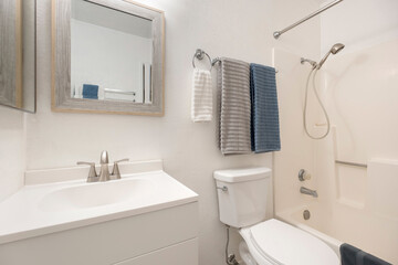 A bathroom with sink, toilet, mirror, and wall painting