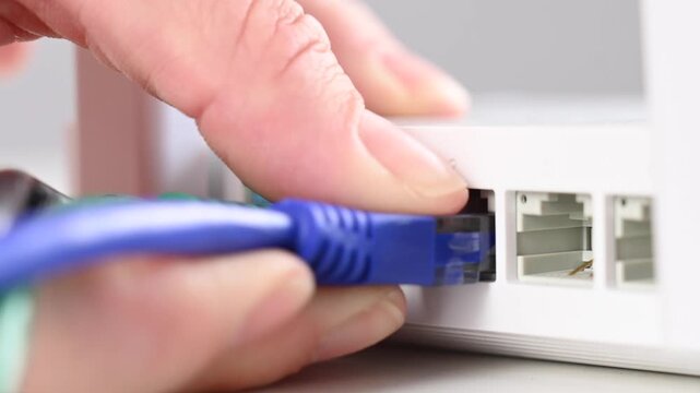 Woman pulling cable out of router. 
