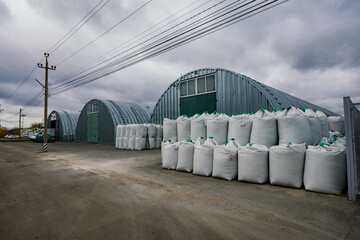 Industrial warehouses with round roof and plastic bags with goods