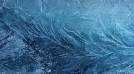 Fototapeta premium Intricate patterns of frost crystals forming delicate feathery shapes on a blue icy surface