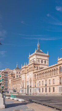 Timelapse of the Cavalry Academy in Plaza de Zorrilla, Valladolid, Spain. Historic military building with intricate architecture, surrounded by a busy urban scene under a blue sky with passing clouds.