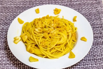 Spaghetti Aglio e Olio with Crispy Garlic on a White Plate