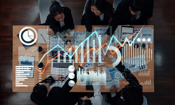 A business team engages in data analysis and strategic planning, surrounded by financial graphs and charts in a modern workspace. Collaboration and insight drive success. Scalp