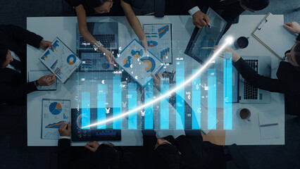 A diverse group of professionals collaborates in a modern office, analyzing financial charts and data visualizations that represent business growth and strategy development. Axiom