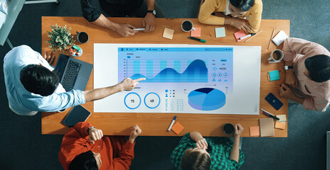 Engaging team meeting focused on data analysis with digital visualization tools on a modern tabletop, showcasing collaboration and innovative thinking in an office. Axiom