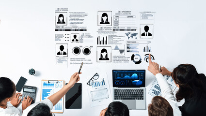 A diverse team collaborates in a business meeting, analyzing data and presenting various graphs while utilizing laptops and visual reports on a modern corporate workspace. Trope