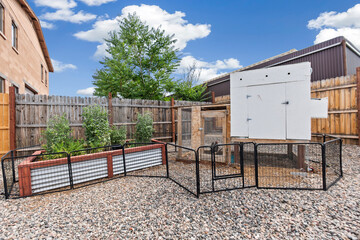 A spacious backyard area featuring a fence and a chicken coop structure © Allison