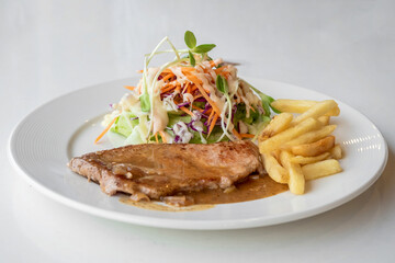 Close up of Grilled pork steak, boiled french fries and vegetable salad;Selective focus