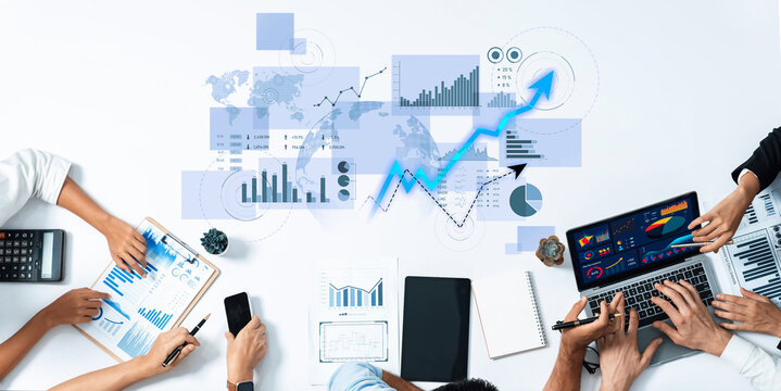 A dynamic team engages in collaboration over business analytics, surrounded by digital devices and data visualizations, showcasing teamwork and innovation in a professional setting. Scalp