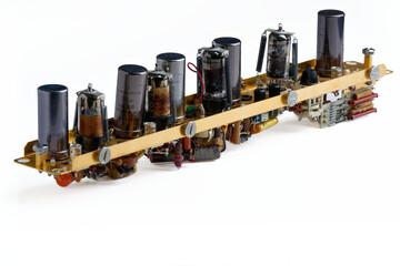 Obsolete vacuum tube radio frequency amplifier module with old electronic components mounted on a metal chassis isolated on white.