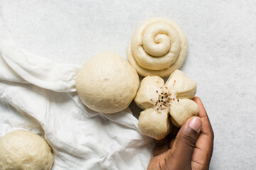 Overhead view of steamed bun on a white countertop, top view of mantou on a white background, process of making steamed milk buns