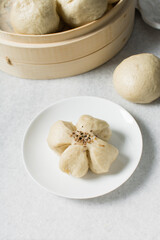 Overhead view of steamed bun on a white countertop, top view of mantou on a white background, process of making steamed milk buns