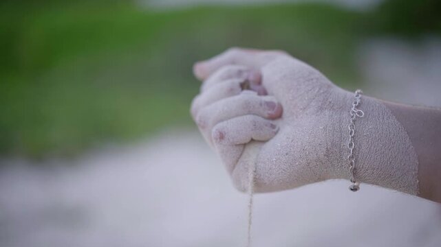Mano dejando caer arena, reloj de area, Closeup