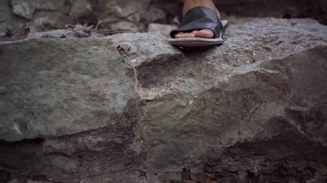 Pies con sandalias, desendiendo escaleras de piedra riviera maya 